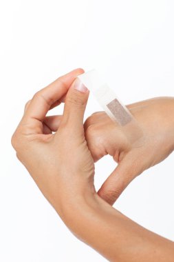 Beyaz arka planda tıbbi bandajlı kadın eli