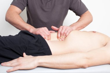 Erkek masaj terapisti hastaya masaj yapıyor, rehabilitasyon tıbbı konsepti 