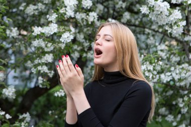Çiçeklere alerjik reaksiyon gösteren sarışın genç bir kadın.