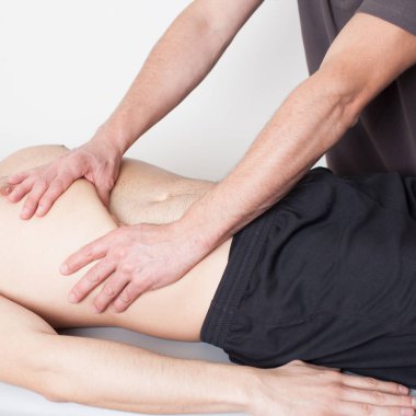 Masaj terapisti karın masajı yapıyor.