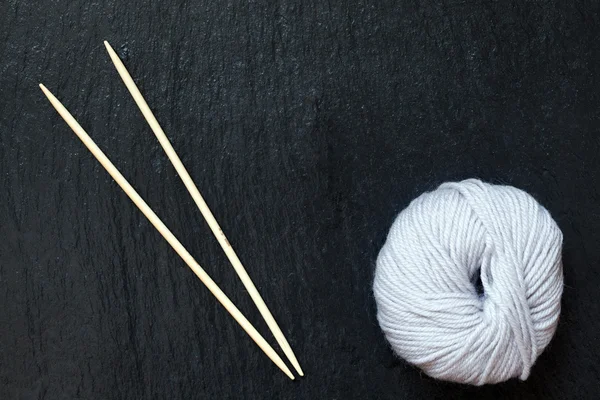 Beyaz iplik siyah arduvaz arka plan bambu örgü iğne ile skein