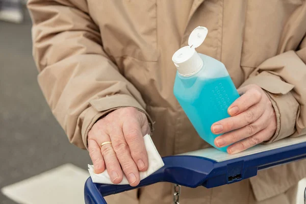 Mans Hand Trzymać Plastikową Butelkę Środkami Dezynfekującymi Pomocą Uchwytu Wózka — Zdjęcie stockowe