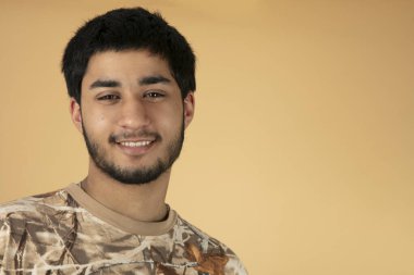 Bej arka planda güzel siyah saçlı adam.