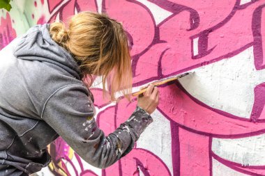 WETZLAR, GERMANY - 23.05.2021: WETZLAR 'daki ev cephesi üzerine yapay tipografi renkli grafiti yapan genç bayan sanatçı; ALMANY