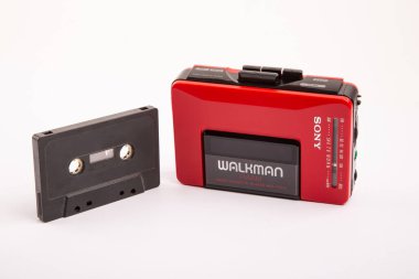 HUETTENBERG, GERMANY - 2021-04-07: Parlak arkaplan üzerinde siyah ses kaseti olan güzel kırmızı renkli SONY WALKMAN WM-24.