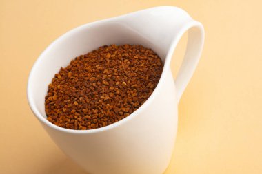 Bej arka planda güzel bir kahve fincanında toz kahve.