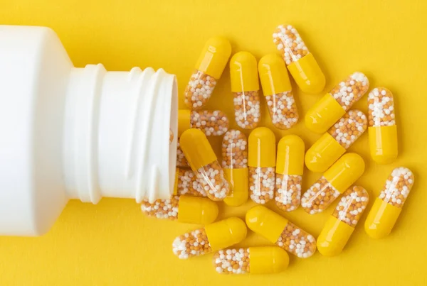 Pastillas Amarillas Con Una Caja Pastillas Blanca Sobre Fondo Amarillo — Foto de Stock