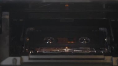 Elle yerleştirme ve bir teyp mekanizmasından şeffaf bir ses kaseti çıkarma