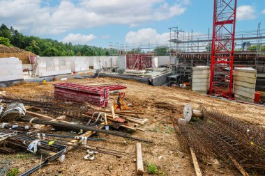 İnşaat halinde vinç ve malzemelerle birlikte prefabrik beton ve tuğla duvarlar kullanılıyor.