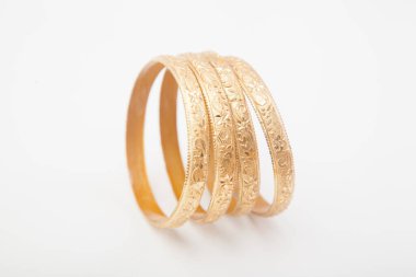 Kenarlarında kabuklu büyük altın bilezikler var.