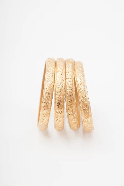 Vertikale Reihe Von Verkrusteten Massiven Goldenen Armbändern Auf Weißem Hintergrund — Stockfoto