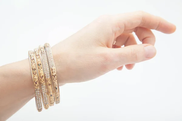 Kvinnlig Hand Med Uppsättning Gyllene Armband Vit Bakgrund Med Selektivt Royaltyfria Stockfoton