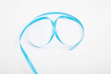 Beyaz üzerine yuvarlanmış mavi dalgalı kurdele seçici odaklı