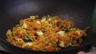 Tavadaki sebzeleri spatulayla karıştırmak.
