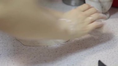 Ellerin yaklaşması hamuru merdaneyle düzleştirmesi