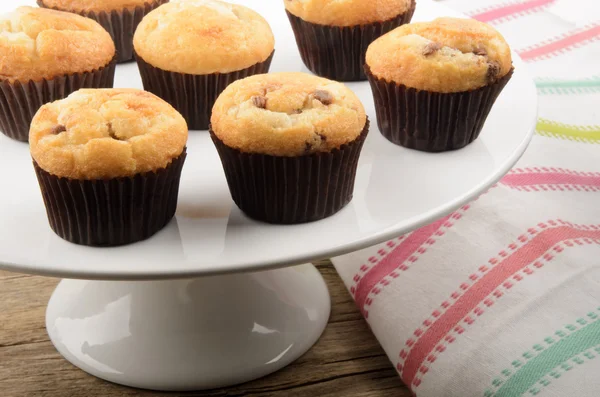 Muffins de chispas de chocolate en un puesto de pastel blanco —  Fotos de Stock