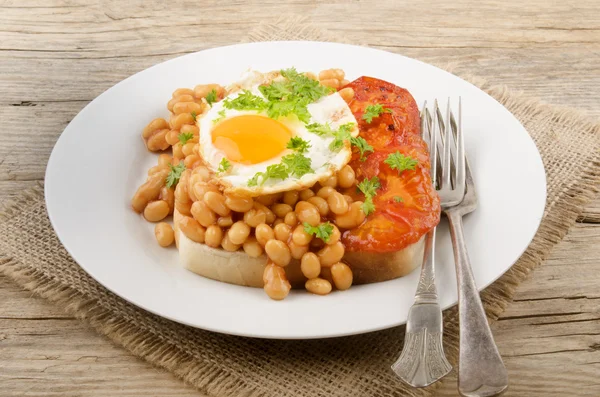 Fried egg with grilled tomato slices and baked beans — Stock Photo, Image