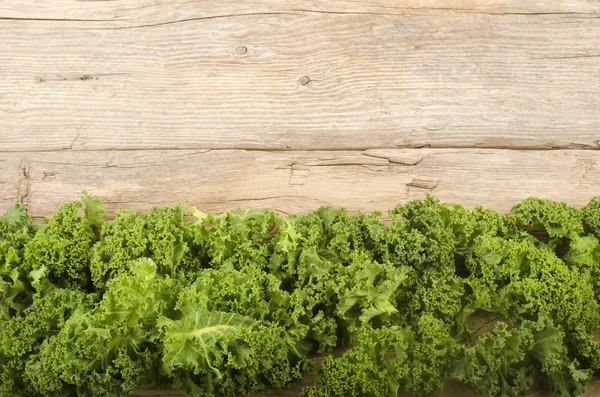 Curly kale on a rustic table — Stock Photo, Image