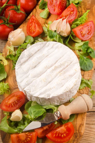 Camembert with salad, tomato, garlic and thyme on wooden board — Stock Photo, Image