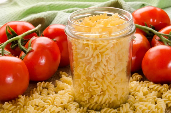 Noodle in a storage glass and tomato — Stock Photo, Image