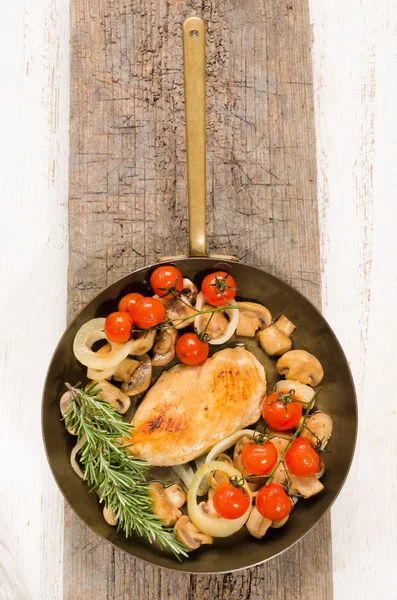 Panela de bronze com filé de peito de frango frito e legumes — Fotografia de Stock