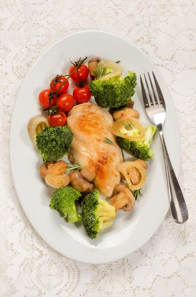 Kycklingbröst filet på en oval skål med grönsaker — Stockfoto