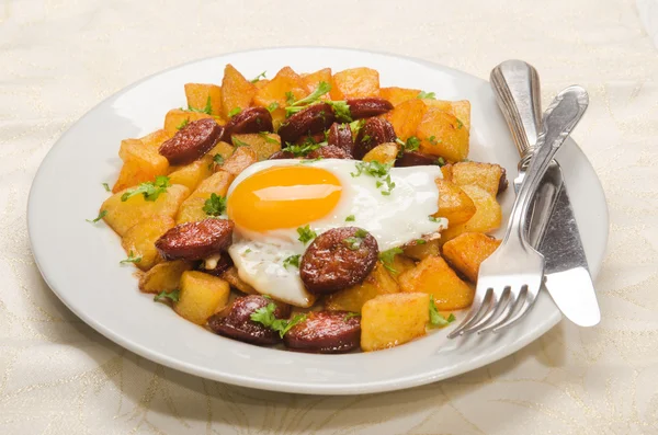Comida española con chorizo en rodajas, patata asada y huevo frito — Foto de Stock