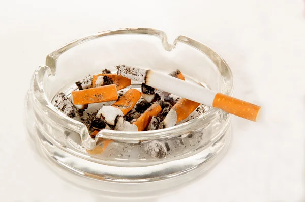 Aschenbecher mit Zigarette auf hellem Hintergrund — Stockfoto
