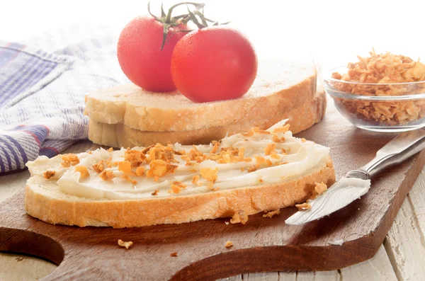 Сніданок зі свинячим салатом і хрусткою цибулею на скибочці хліба — стокове фото