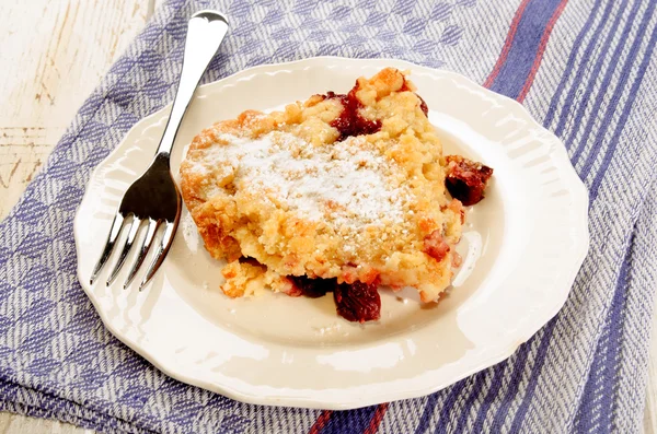 Home made cherry crumble with powdered sugar on a plate — Stock Photo, Image