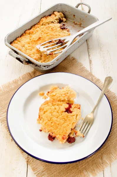Home made cherry crumble on enamel plate — Stock Photo, Image