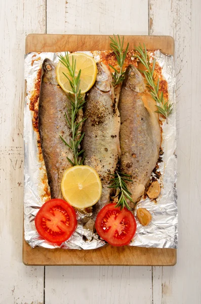 Baked trout with lemon and sliced tomato — Stock Photo, Image