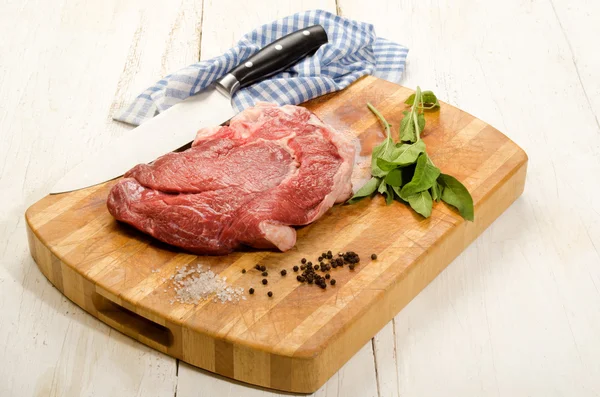 Raw beef shoulder on wooden board with sage — Stock Photo, Image