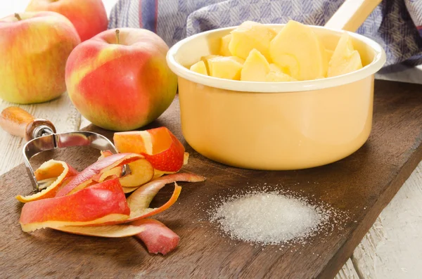 Свіжі і нарізані шматочки яблука і цукор для приготування яблучного компоту — стокове фото