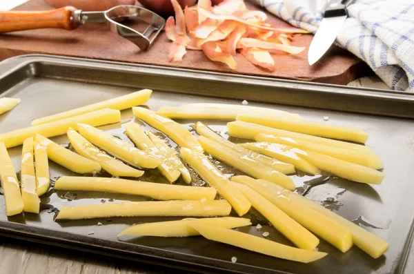 Patatas fritas recién cortadas en una lata para asar —  Fotos de Stock