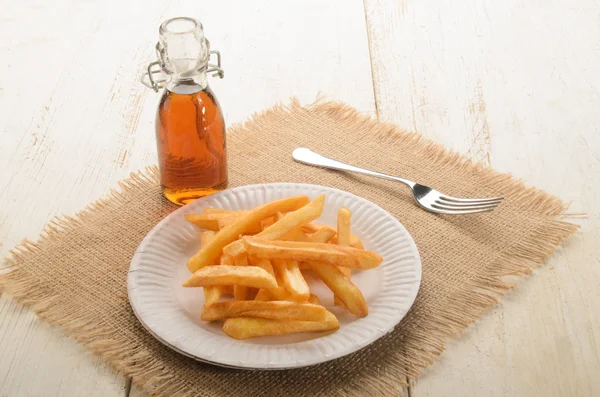 Pommes frites på ett papper plattan och malt vinäger — Stockfoto