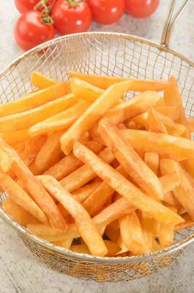 Batatas fritas da fritadeira em uma peneira — Fotografia de Stock