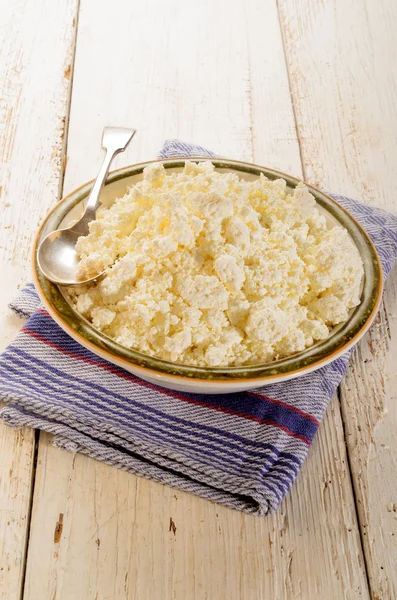 Cottage cheese and spoon in a bowl — Stock Photo, Image