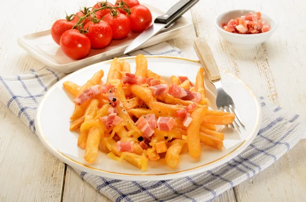 Cubitos de tocino ahumado y papas fritas de color marrón dorado con che derretido —  Fotos de Stock