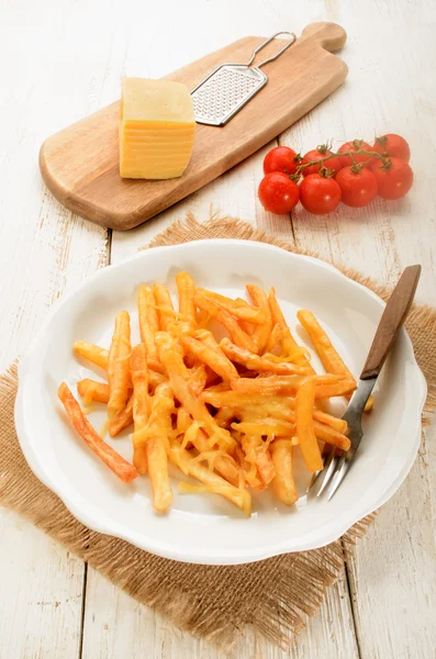 Papas fritas de color marrón dorado con queso derretido en un plato — Foto de Stock