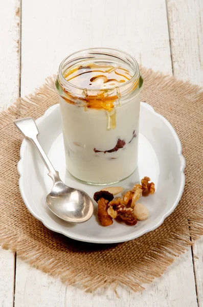 Greek yogurt with nuts and sweet honey in a glass — Stock Photo, Image