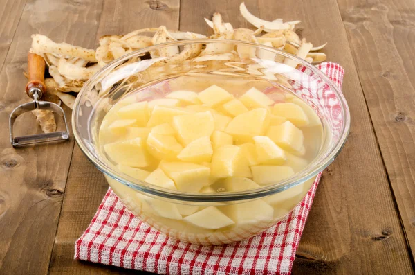 Diced potatoes in a glass bowl with water — Stock Photo, Image