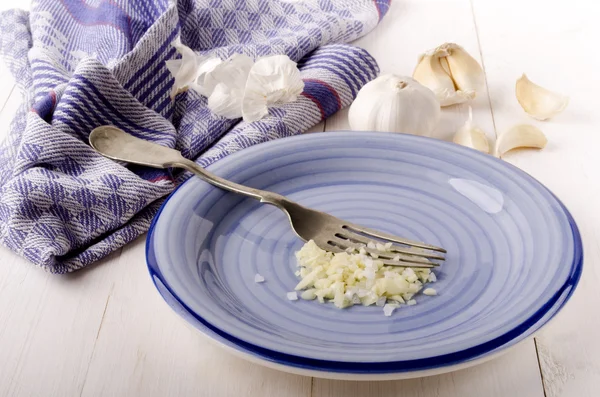 Gehakte knoflook en grof zout op een bord — Stockfoto