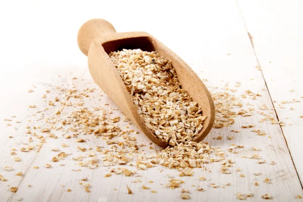 Salvado de trigo crudo en una cucharada de madera — Foto de Stock