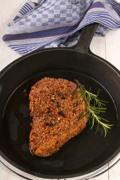 Raw peppered pork chop in a cast iron pan — Stock Photo, Image