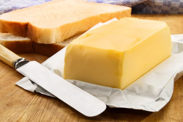 Irish butter with fresh sliced bread on a wooden board — Stock Photo, Image