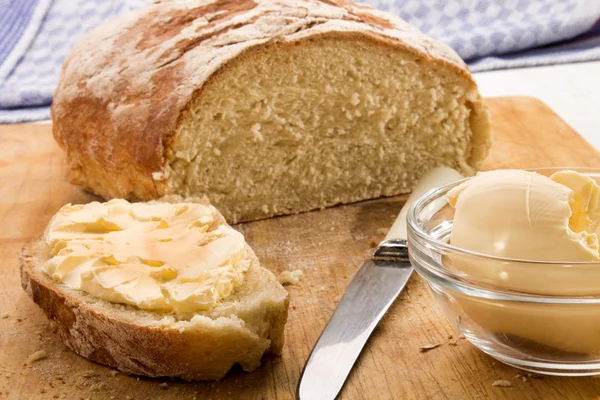 Rebanada de pan de campo recién horneado con mantequilla —  Fotos de Stock