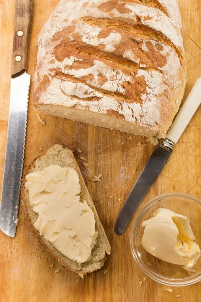 Rebanada de pan de campo recién horneado con mantequilla —  Fotos de Stock
