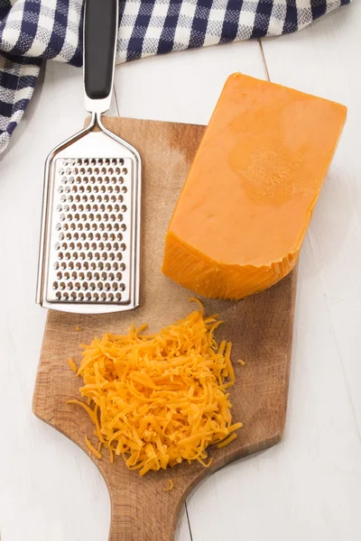 Ιρλανδική ώριμη cheddar τριμμένο τυρί σε ένα ξύλινο ταμπλό με — Φωτογραφία Αρχείου