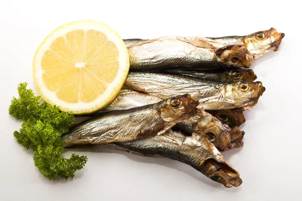 Smoked sprats with lemon and parsley on bright background — Stock Photo, Image